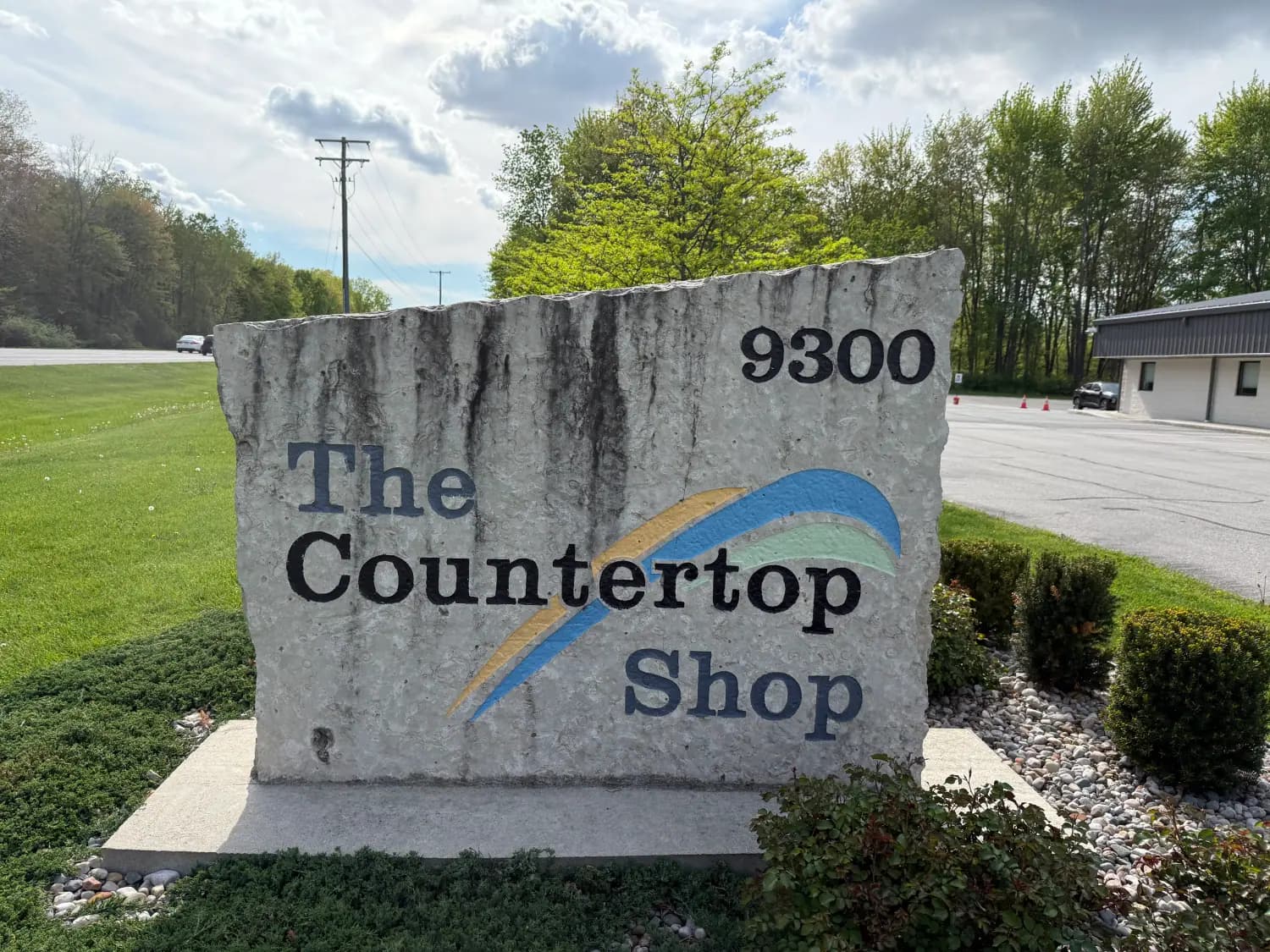 A commercial monument sign before cleaning, stained and weathered